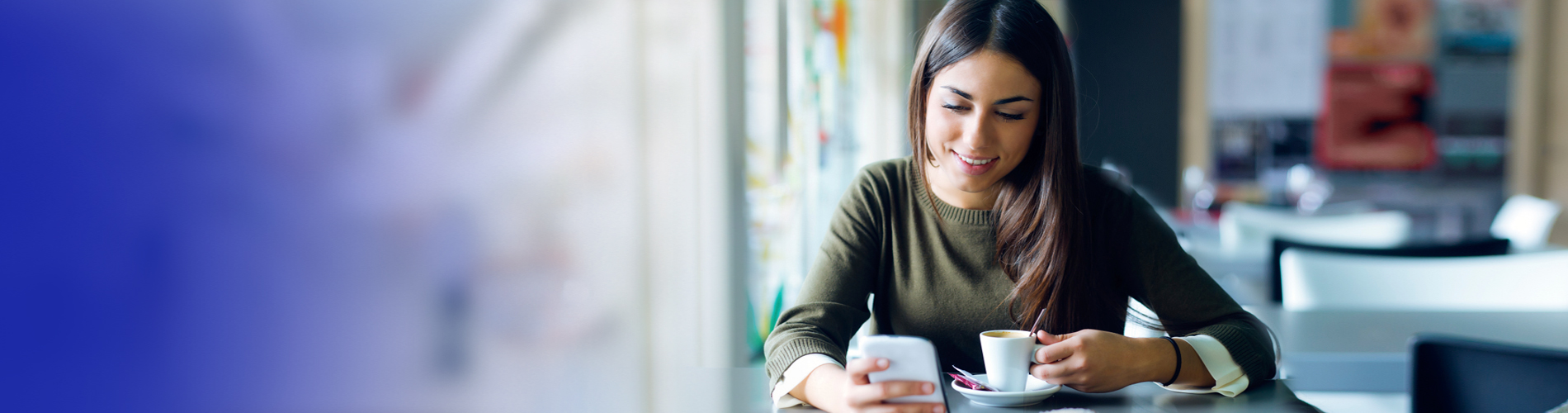 A woman having coffee and using her smartphone